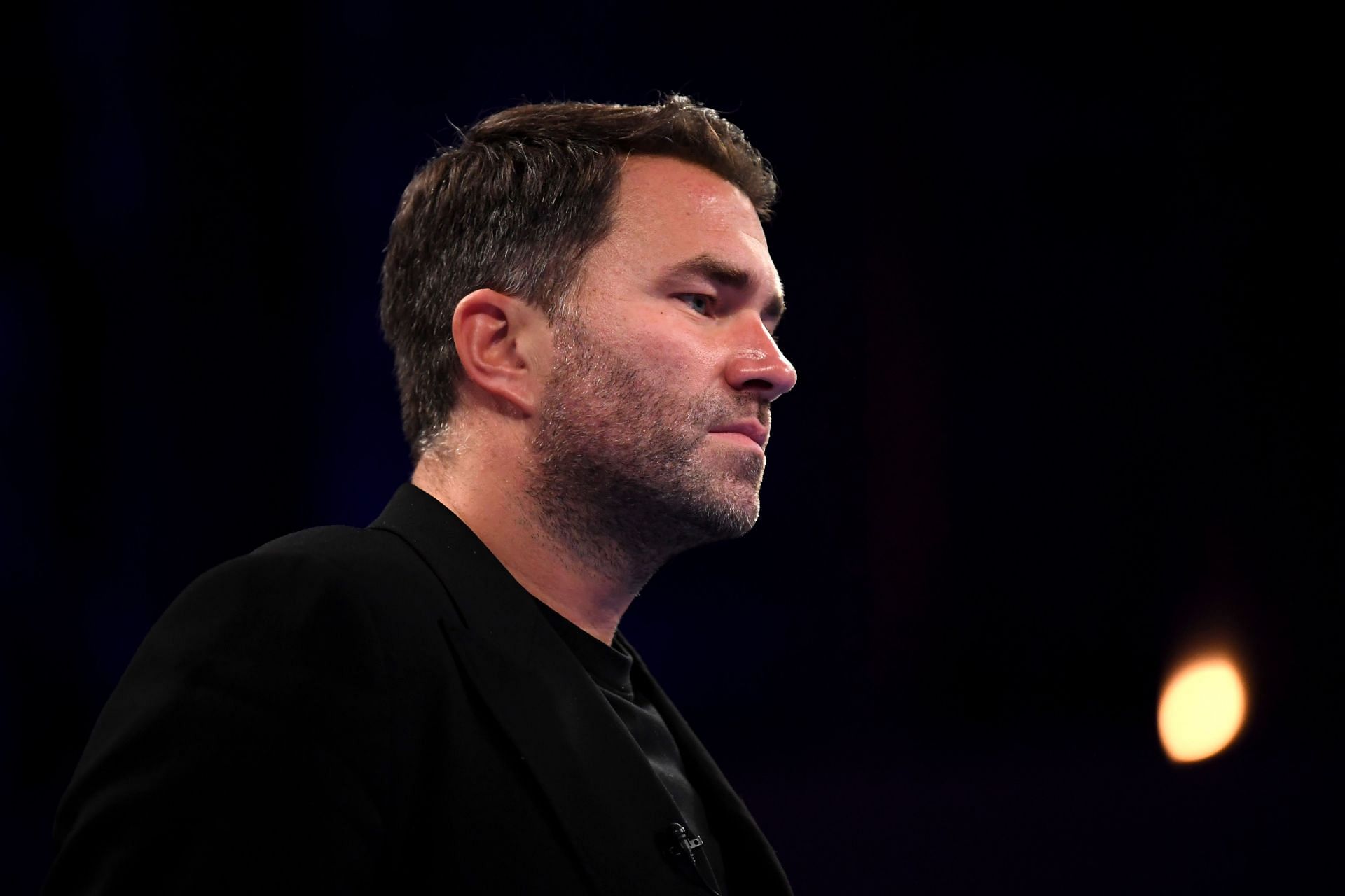 Eddie Hearn watching super middle-weight fight at Alexandria Palace.