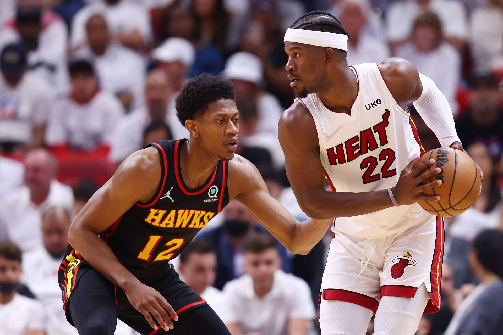 Jimmy Butler No. 22 of the Miami Heat is defended by De'Andre Hunter No. 12 of the Atlanta Hawks.