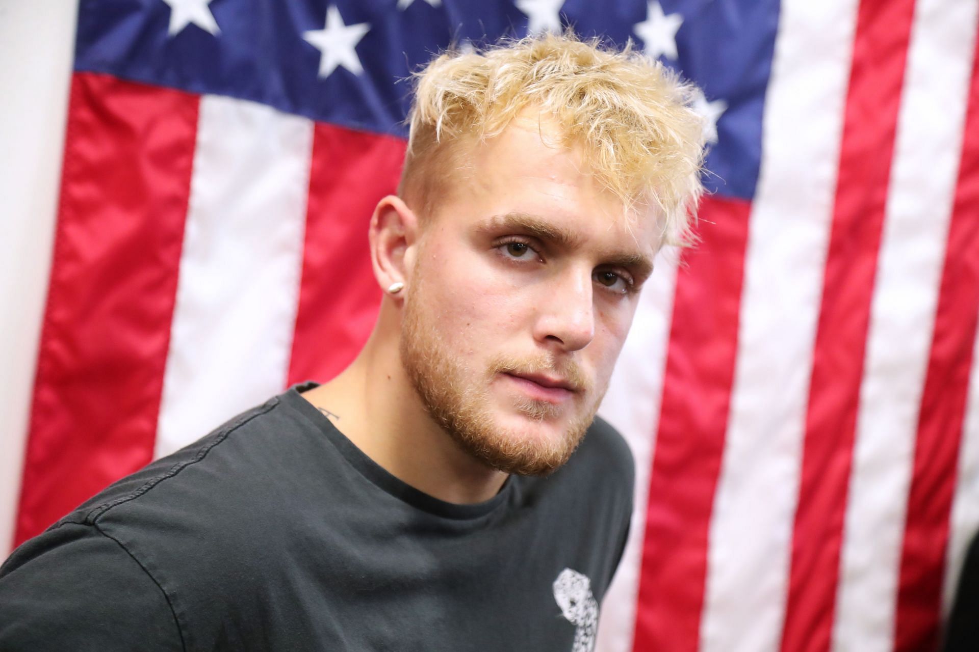 Jake Paul posing in front of the American flag