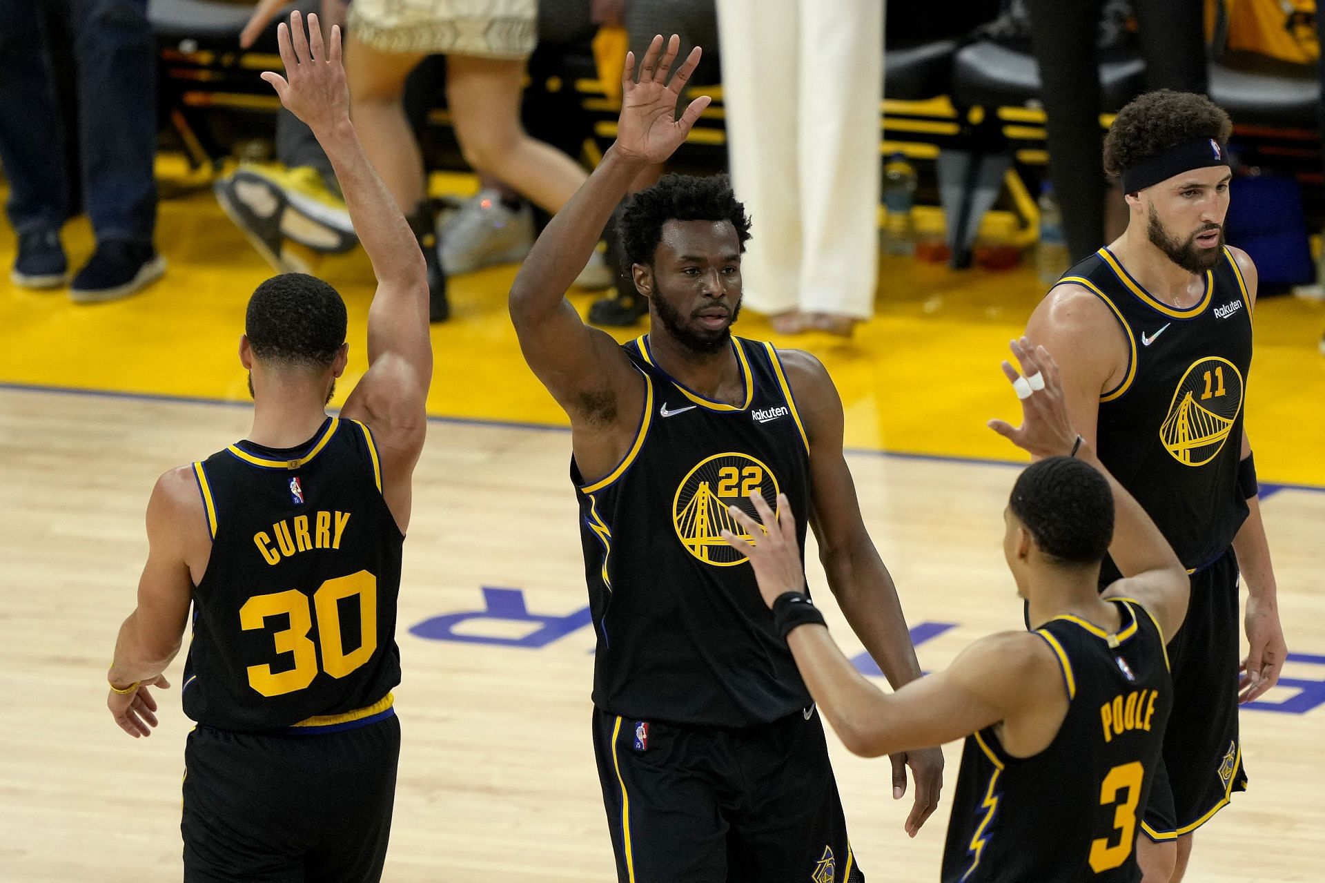 Andrew Wiggins of the Golden State Warriors high-fives Steph Curry and Jordan Poole during Game 1 of the Western Conference finals.