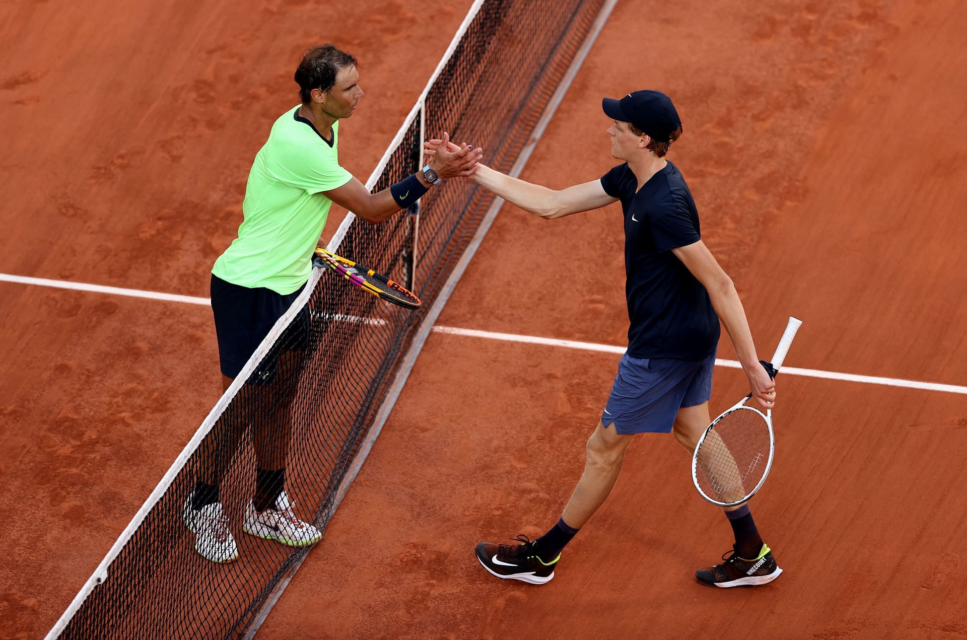 Rafael Nadal and Jannik Sinner shake hands after their match at the 2021 French Open