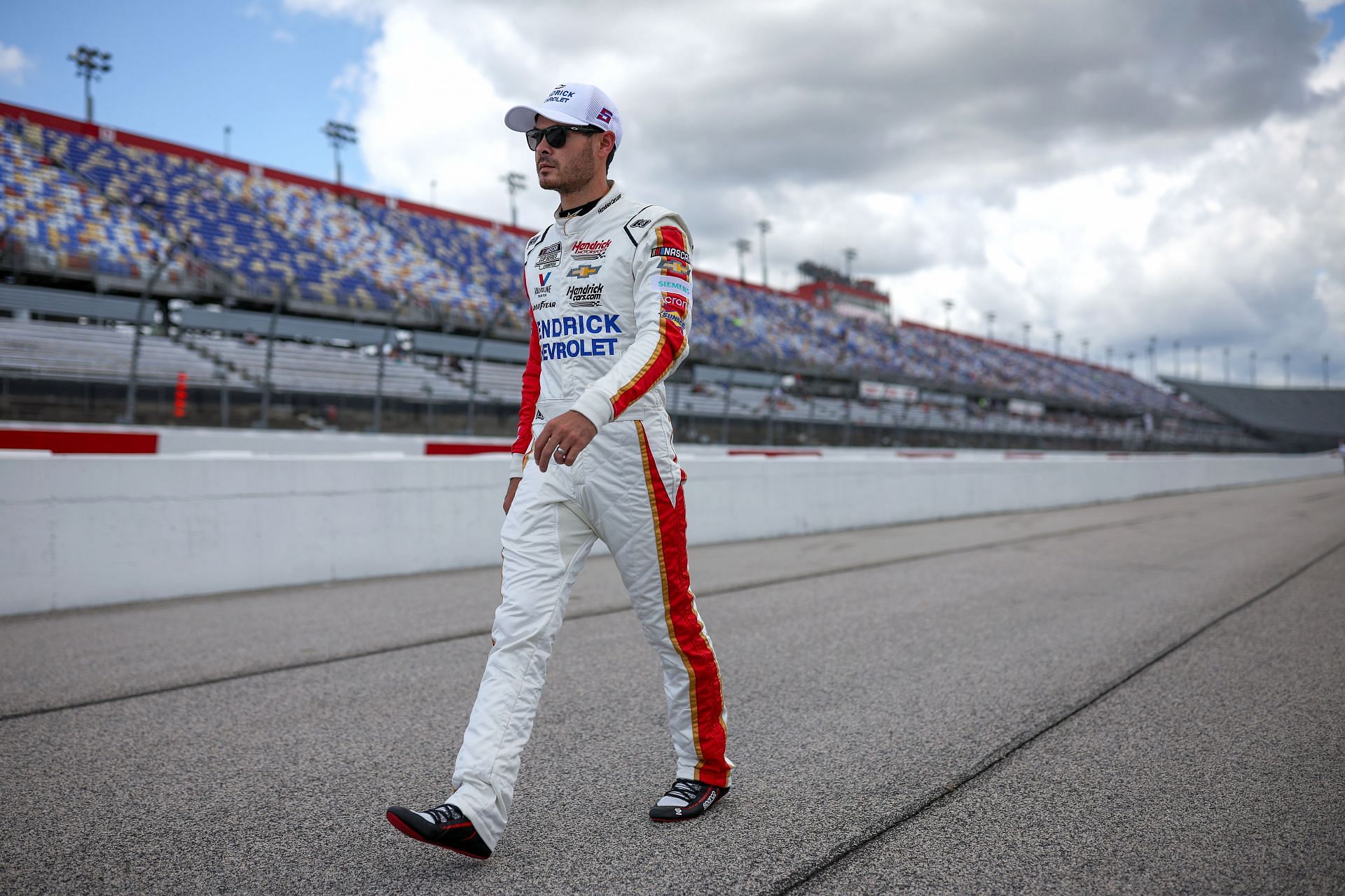Kyle Larson walks on the grid during qualifying for the 2022 NASCAR Cup Series Goodyear 400 at Darlington Raceway in Darlington, South Carolina. (Photo by James Gilbert/Getty Images)