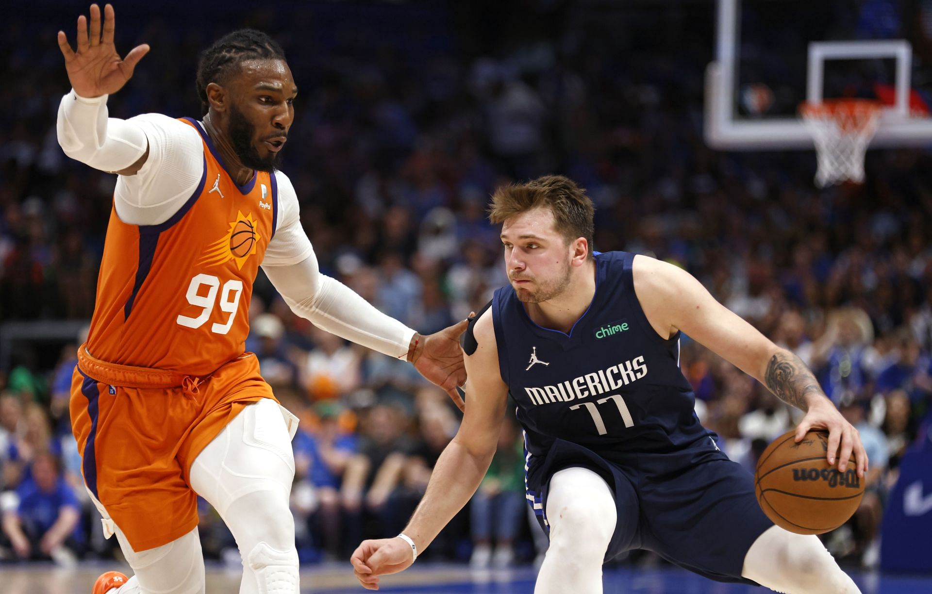 Luka Doncic of the Dallas Mavericks handles the ball as Jae Crowder of the Phoenix Suns