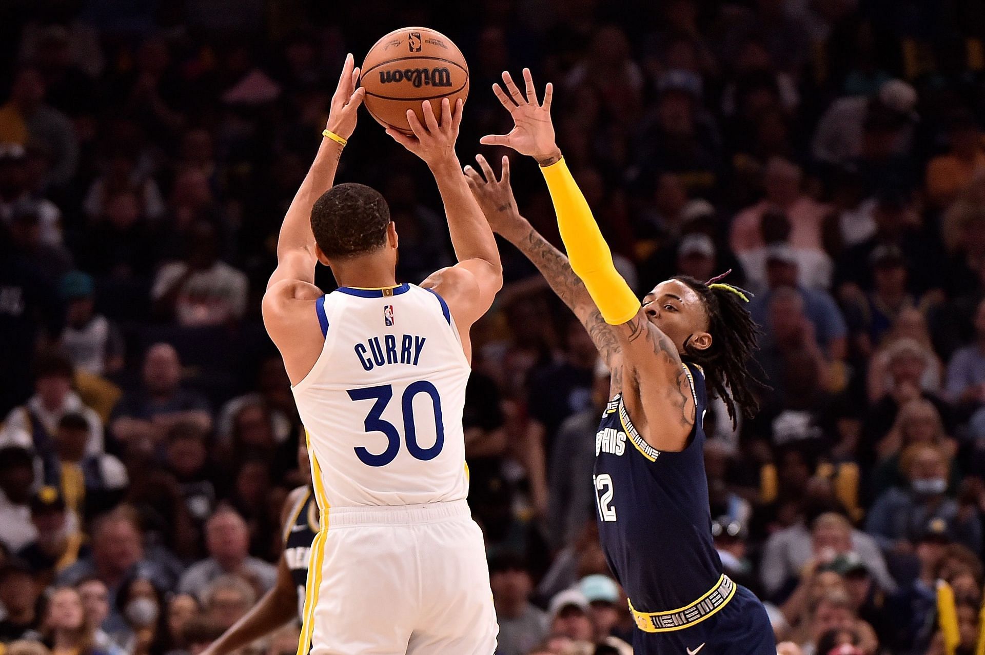 Steph Curry of the Golden State Warriors shoots over Ja Morant of the Memphis Grizzlies