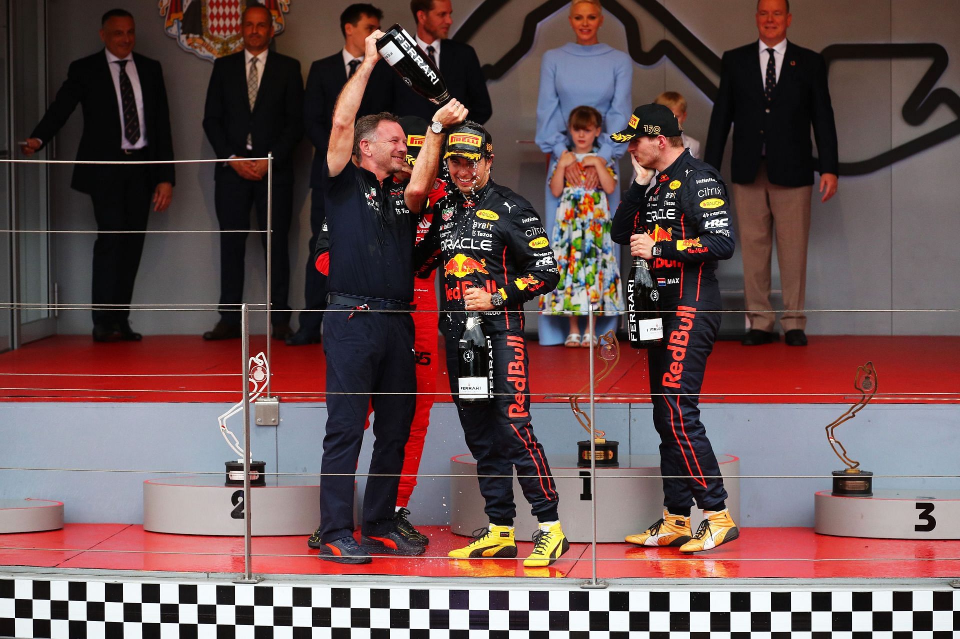 (L to R) Christian Horner, Sergio Perez, and Max Verstappen celebrate on the podium after the F1 Grand Prix of Monaco (Photo by Eric Alonso/Getty Images)