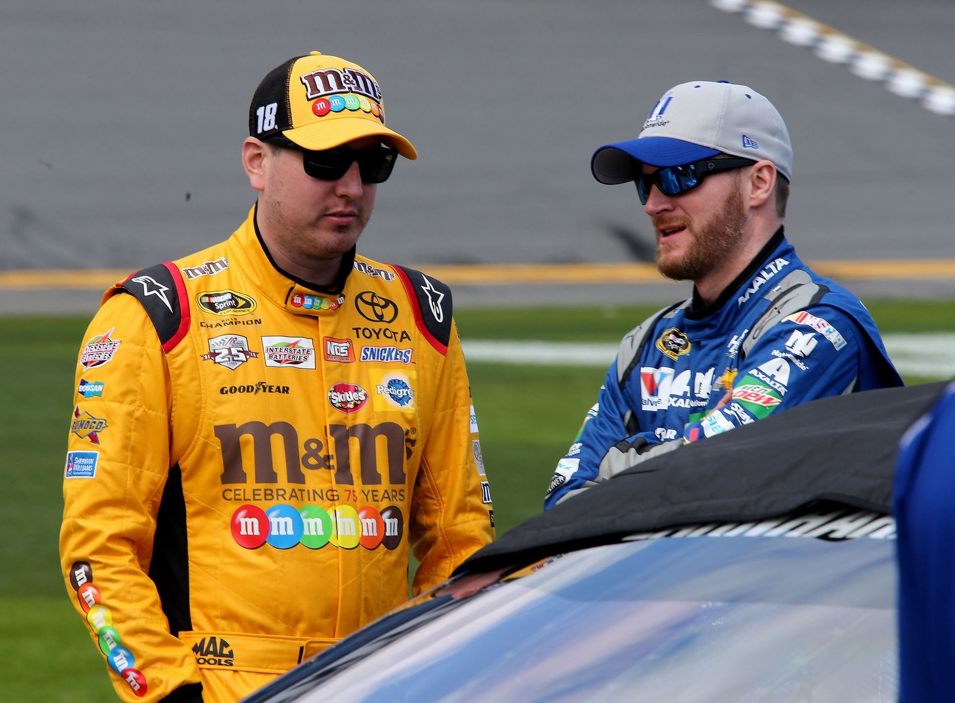 Kyle Busch (left) talks with Dale Earnhardt Jr. (right) on the grid during the 2016 NASCAR Sprint Cup Series Daytona 500 (Photo by Jerry Markland/Getty Images)