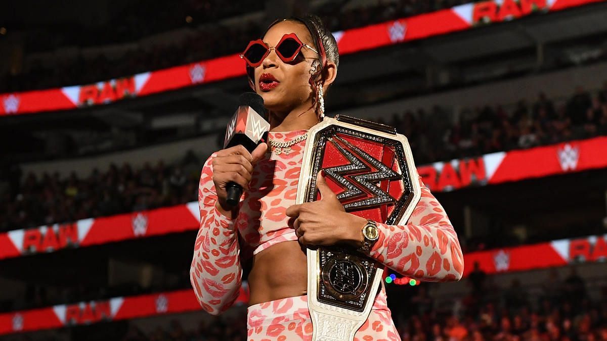 Bianca Belair delivering a promo and posing with her title