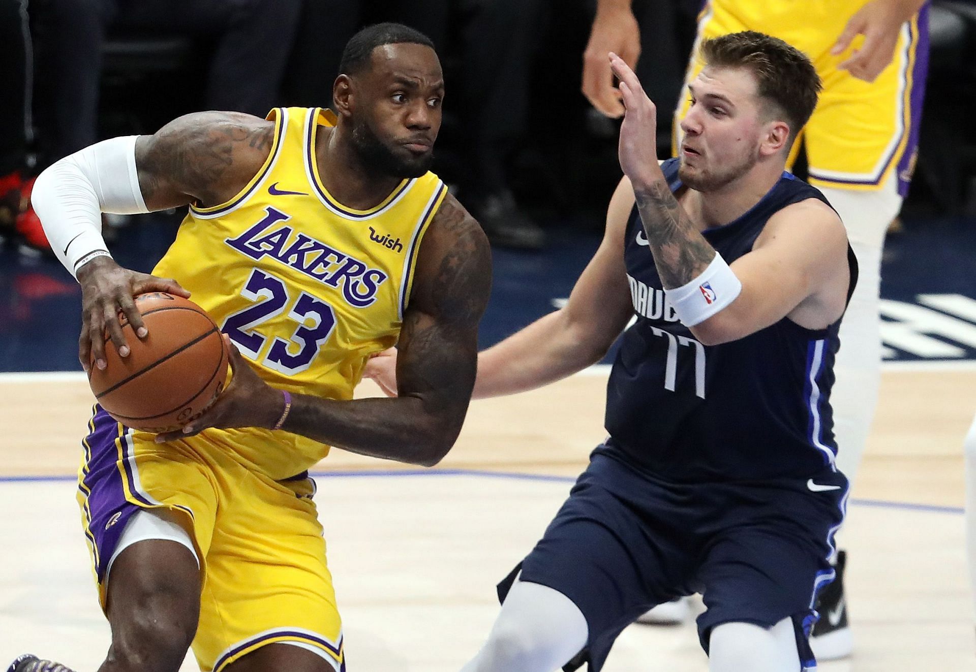 LeBron James (left) drives to the basket against Luka Doncic.