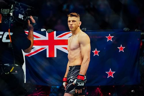 Dan Hooker standing in front of the New Zealand flag at UFC 266 (Images via Getty)