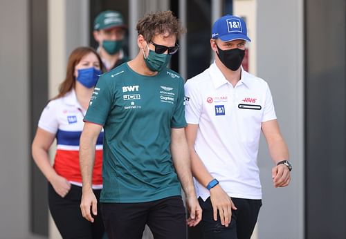 Sebastian Vettel and Mick Schumachertalk in the Paddock during previews ahead of the F1 Grand Prix of Abu Dhabi at Yas Marina Circuit on December 09, 2021 (Photo by Lars Baron/Getty Images)