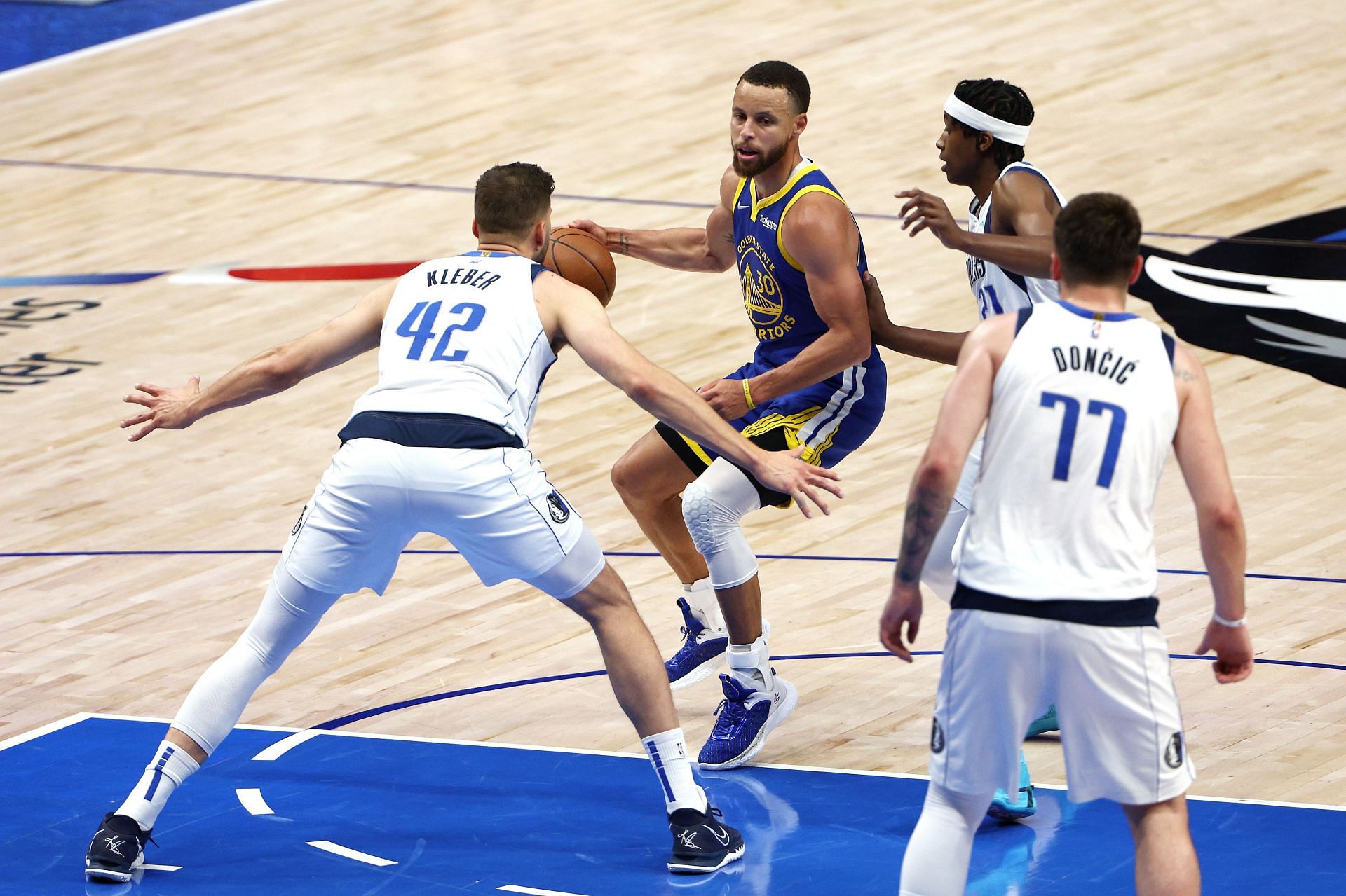 Steph Curry getting defended by three Dallas Mavericks players in Game 4.