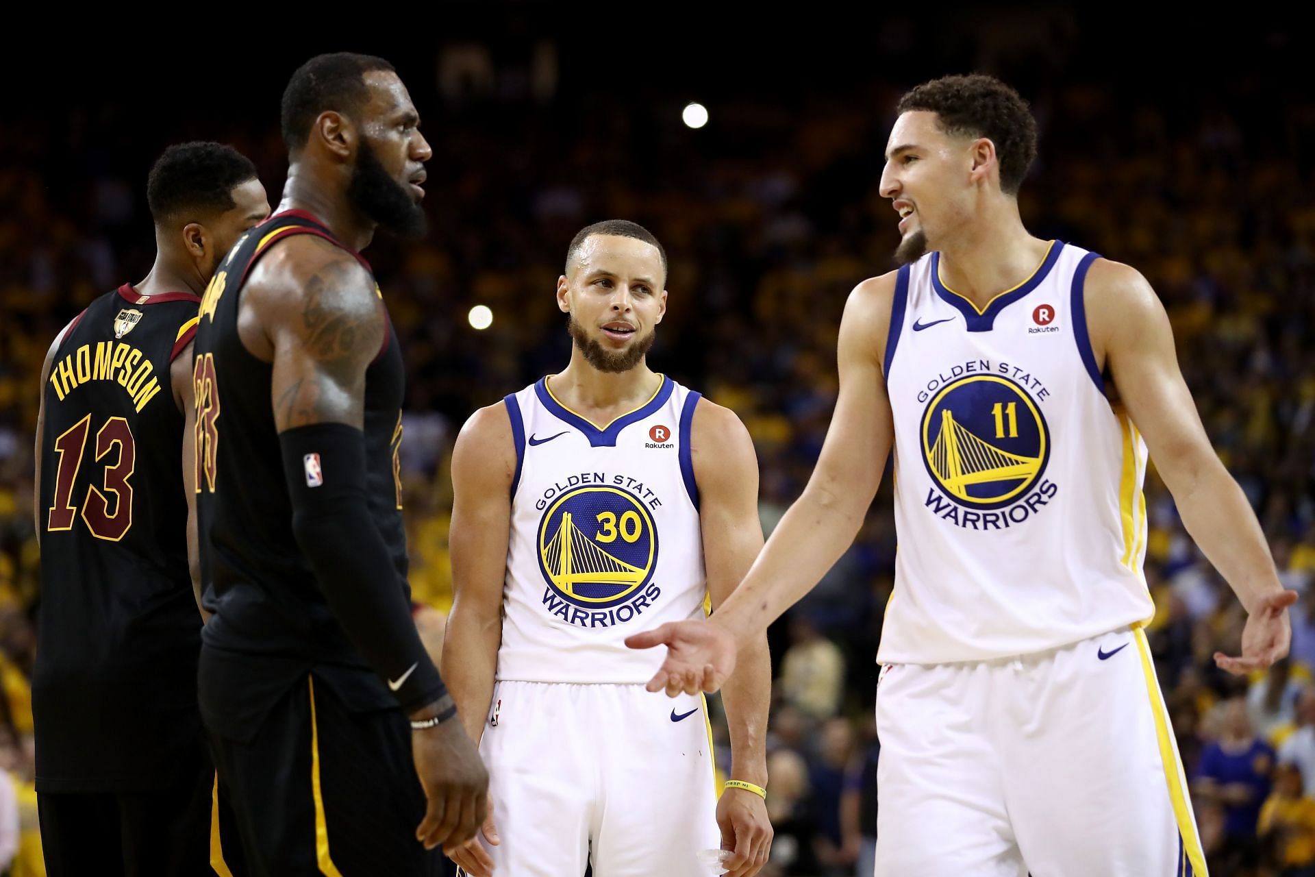 Stephen Curry #30 and Klay Thompson #11 of the Golden State Warriors exchange words with LeBron James #23 of the Cleveland Cavaliers