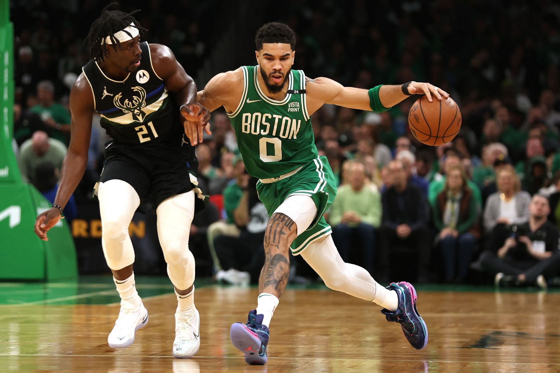 Jayson Tatum #0 of the Boston Celtics drives down court against Jrue Holiday #21 of the Milwaukee Bucks