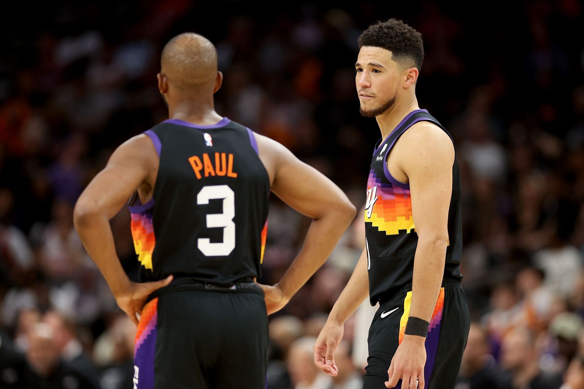 Devin Booker #1 of the Phoenix Suns talks with Chris Paul #3