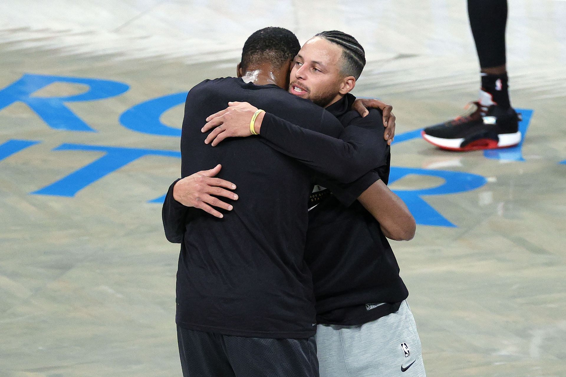 Kevin Durant of the Brooklyn Nets hugs Stephen Curry of the Golden State Warriors during warmups.