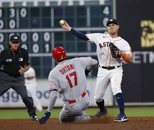 Aledmys Diaz of the Houston Astros throws to first base over Shohei Ohtani of the Los Angeles Angels.