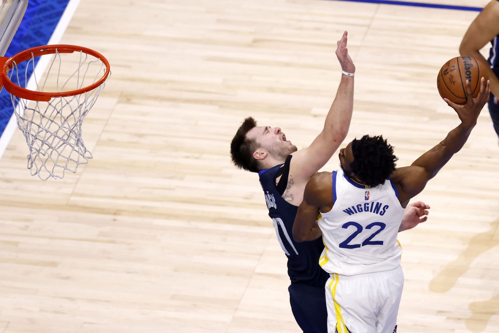 Andrew Wiggins of the Golden State Warriors dunks on Luka Doncic of the Dallas Mavericks in Game 3,