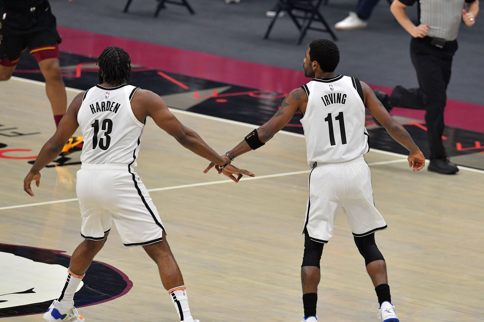 James Harden #13 and Kyrie Irving #11 of the Brooklyn Nets celebrate a play during the first quarter against the Cleveland Cavaliers at Rocket Mortgage Fieldhouse on January 22, 2021 in Cleveland, Ohio.