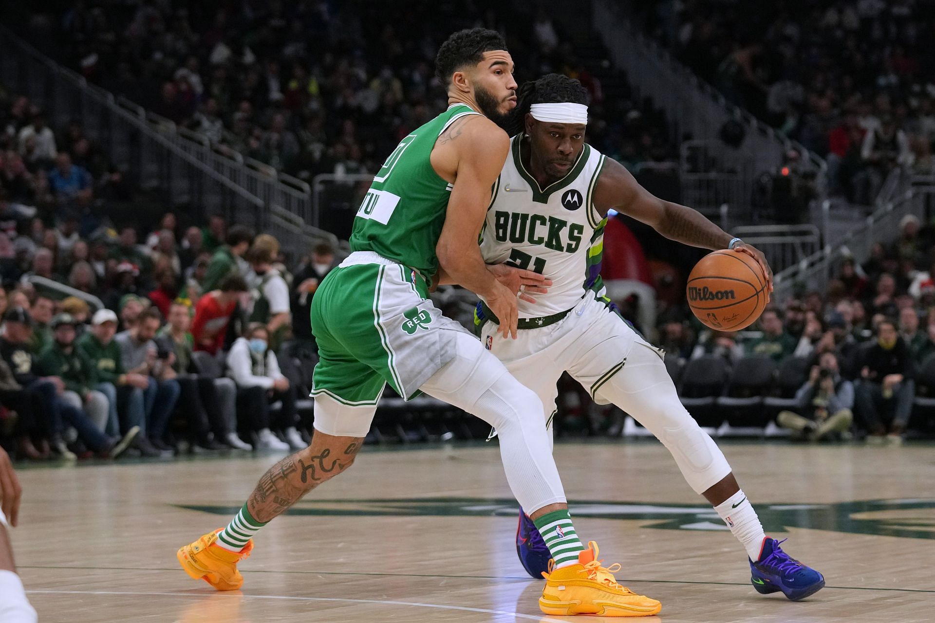 Jrue Holiday #21 of the Milwaukee Bucks dribbles the ball against Jayson Tatum #0 of the Boston Celtics