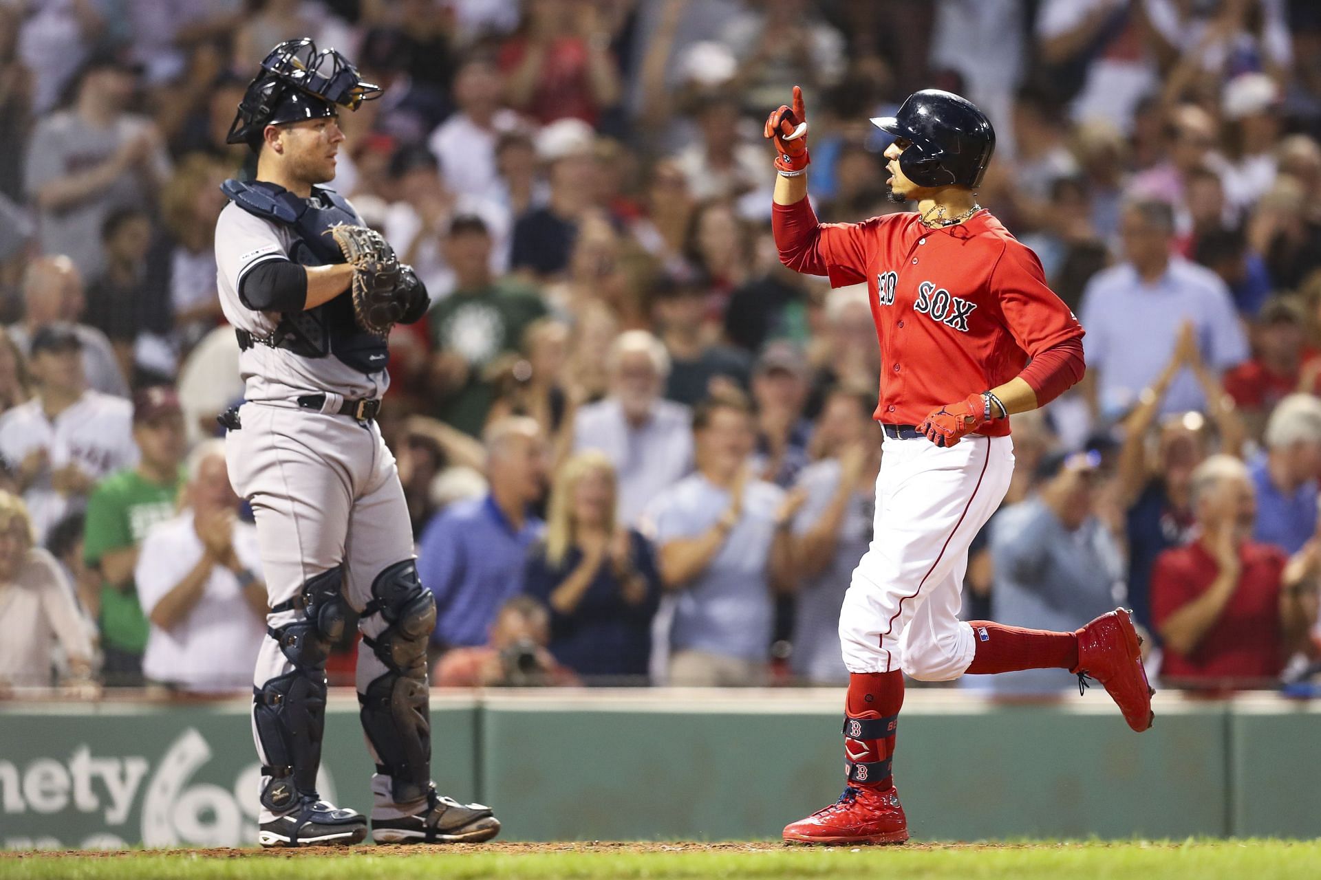 Mookie Betts of the Boston Red Sox reacts as he crosses home plate.