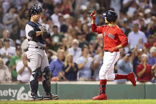 Mookie Betts of the Boston Red Sox reacts as he crosses home plate.