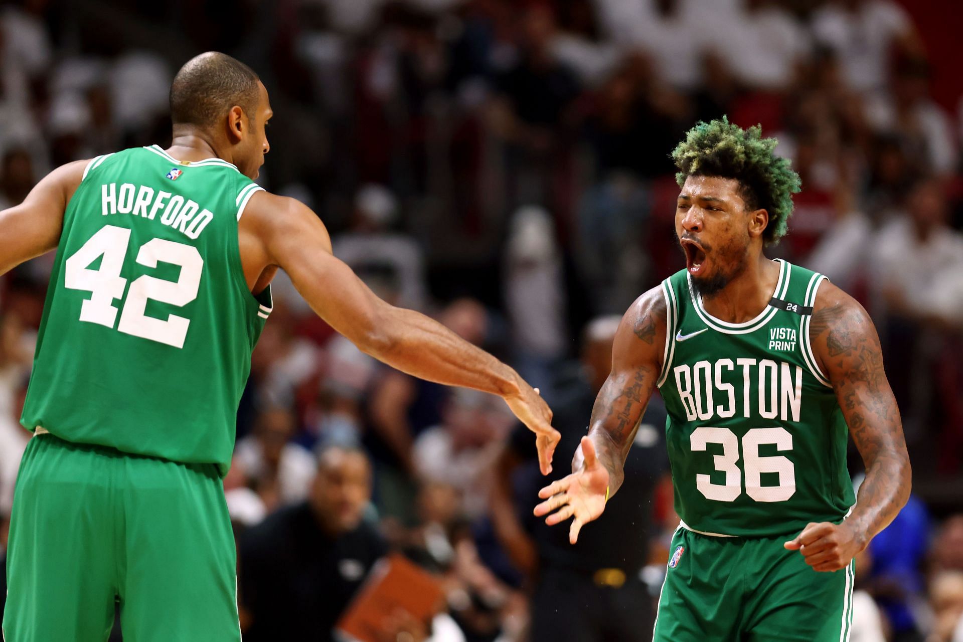 Marcus Smart of the Boston Celtics celebrates a three-point basket with teammate Al Horford.