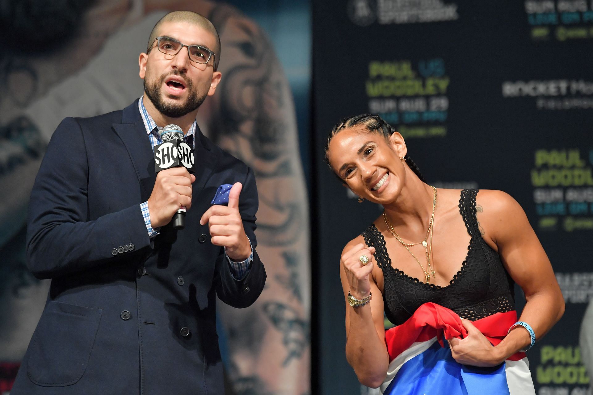 Ariel Helwani (left) with Amanda Serrano (right) at the Jake Paul vs. Tyron Woodley Weigh In (Image via Getty)