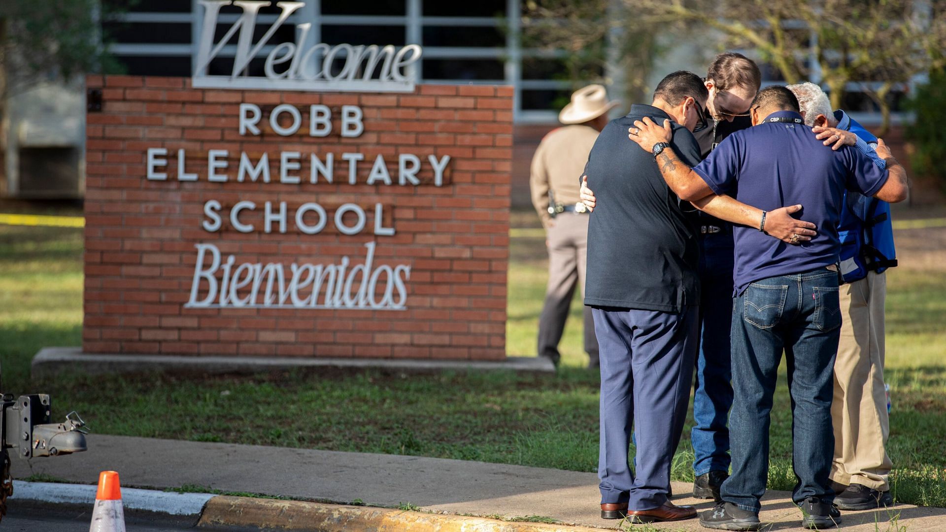 Parents hug outside Robb Elementary School (Image via Ivan Pierre Aguirre for The New York Times)