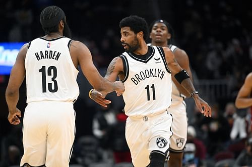 James Harden #13 celebrates with Kyrie Irving #11 of the Brooklyn Nets after the Nets scored during the third quarter against the Cleveland Cavaliers at Rocket Mortgage Fieldhouse on January 17, 2022 in Cleveland, Ohio.