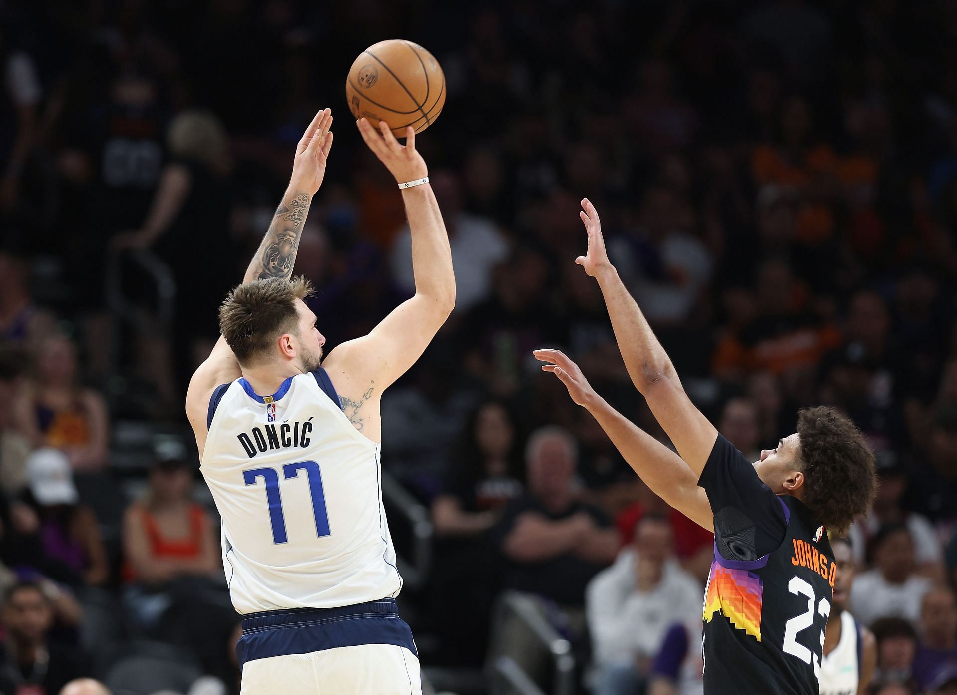 Luka Doncic of the Dallas Mavericks shoots over Cameron Johnson of the Phoenix Suns