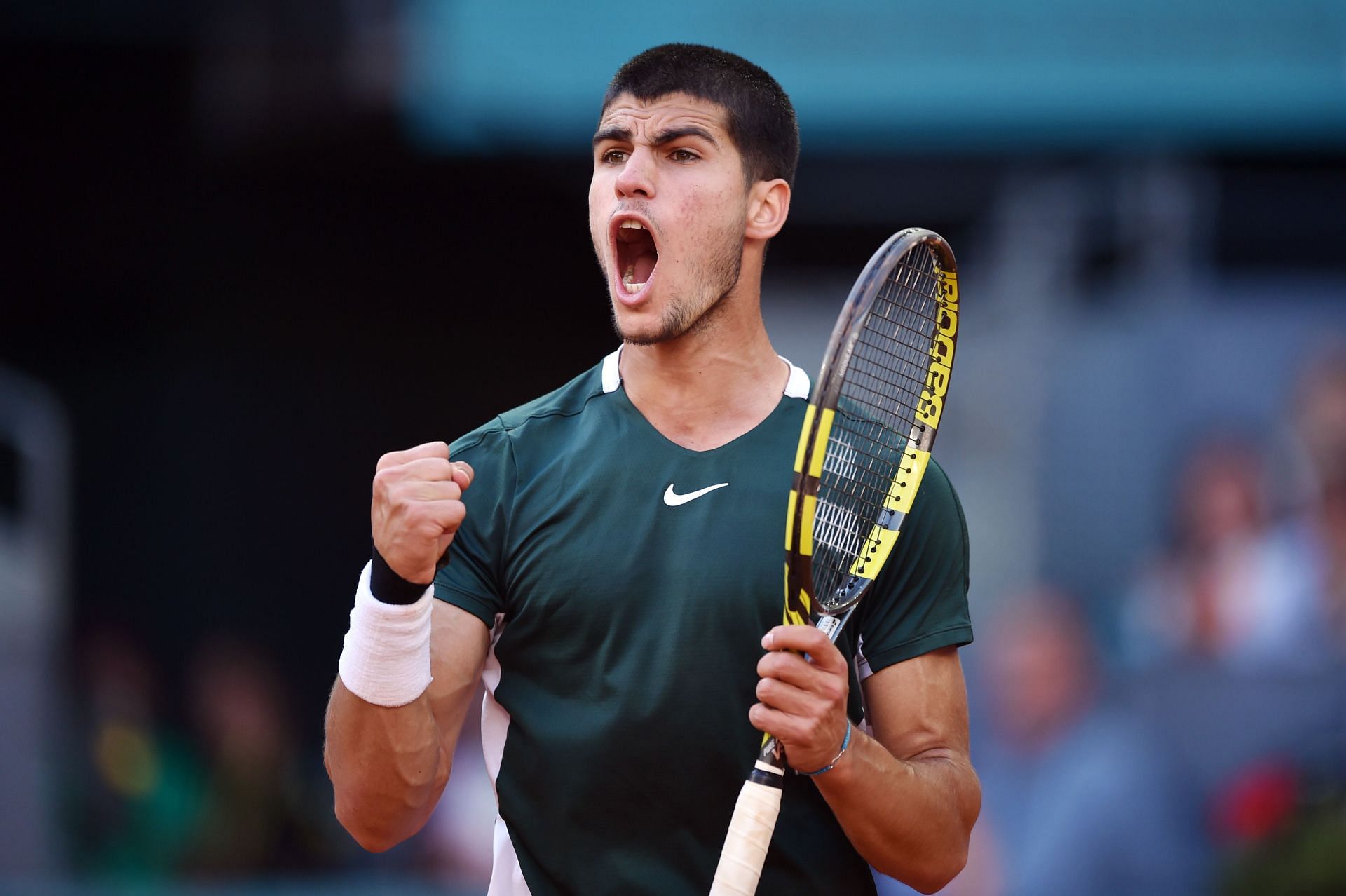 Alcaraz gestures after defeating Novak Djokovic at the Madrid Open