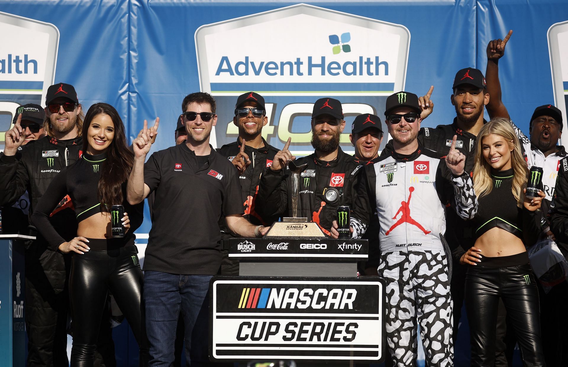 Denny Hamlin, Kurt Busch, and crew celebrate in victory lane after winning the 2022 NASCAR Cup Series AdventHealth 400 at Kansas Speedway (Photo by Chris Graythen/Getty Images)