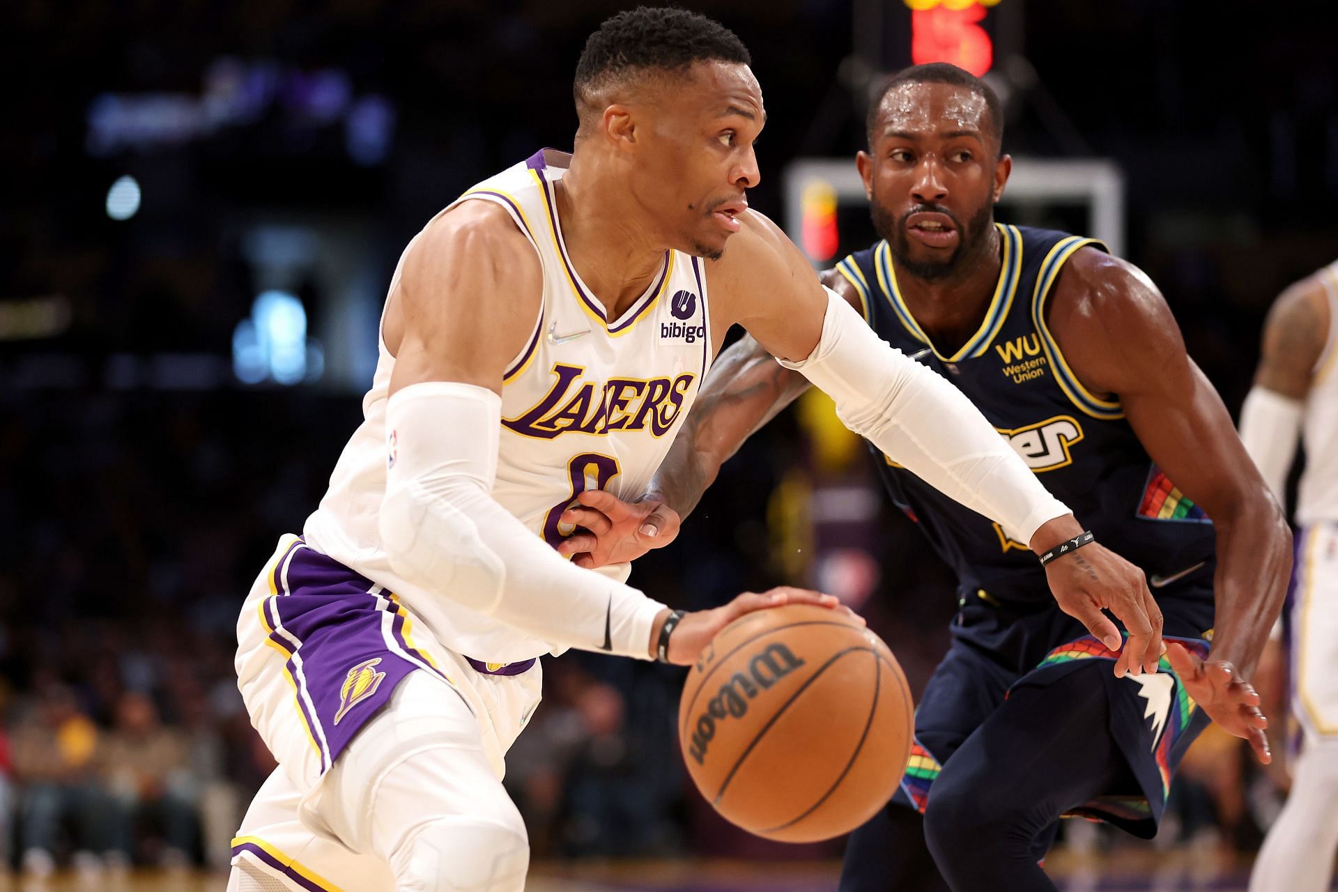Russell Westbrook of the Los Angeles Lakers dribbles past the defense of Davon Reed.