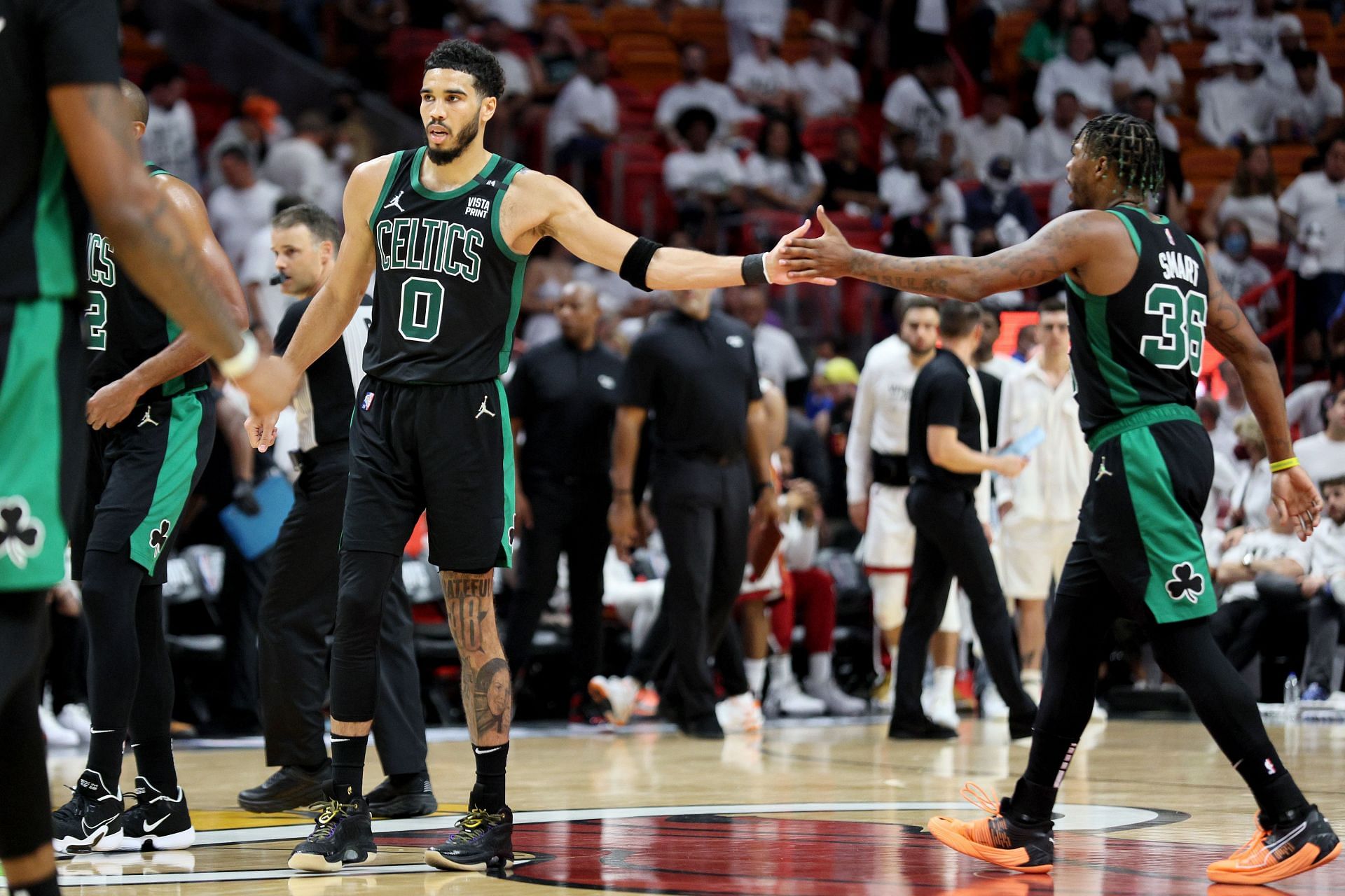 Jayson Tatum #0 of the Boston Celtics high-fives teammate Marcus Smart #36 against the Miami Heat during the fourth quarter in Game Five of the 2022 NBA Playoffs Eastern Conference Finals at FTX Arena on May 25, 2022 in Miami, Florida.