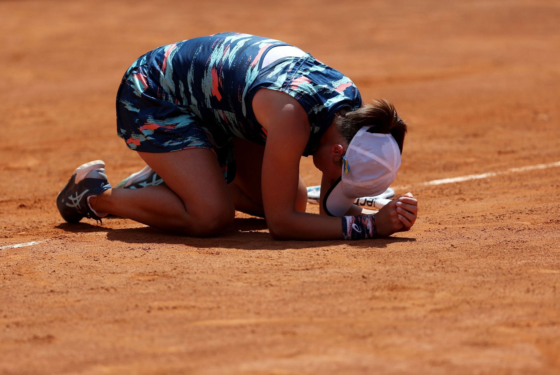 World No. 1 Iga Swiatek drops to her knees after successfully defending her title for the first time in Rome.