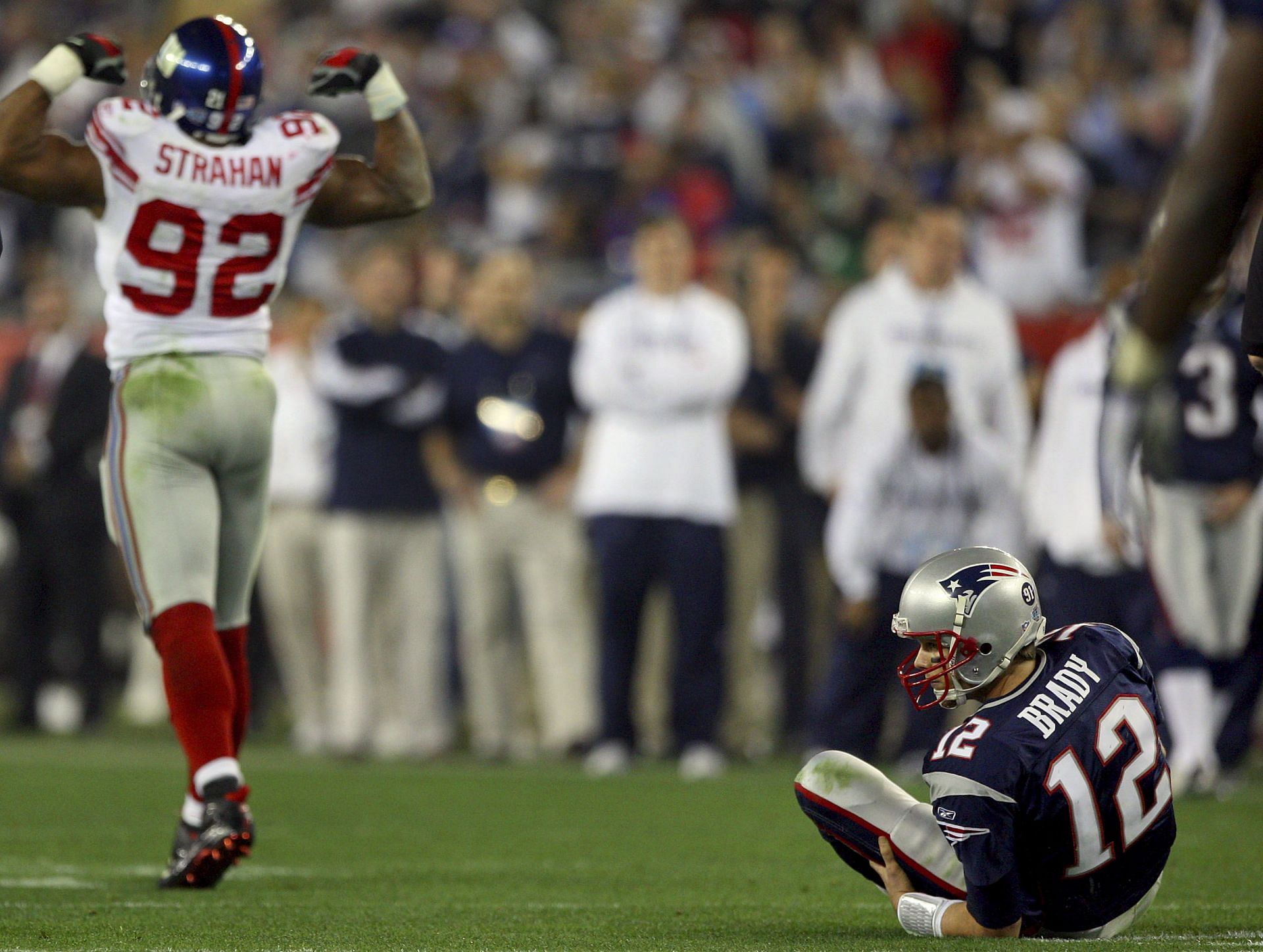 Tom Brady (#12) of the New England Patriots after being tackled by Michael Strahan (#92) of the New York Giants; Super Bowl XLII