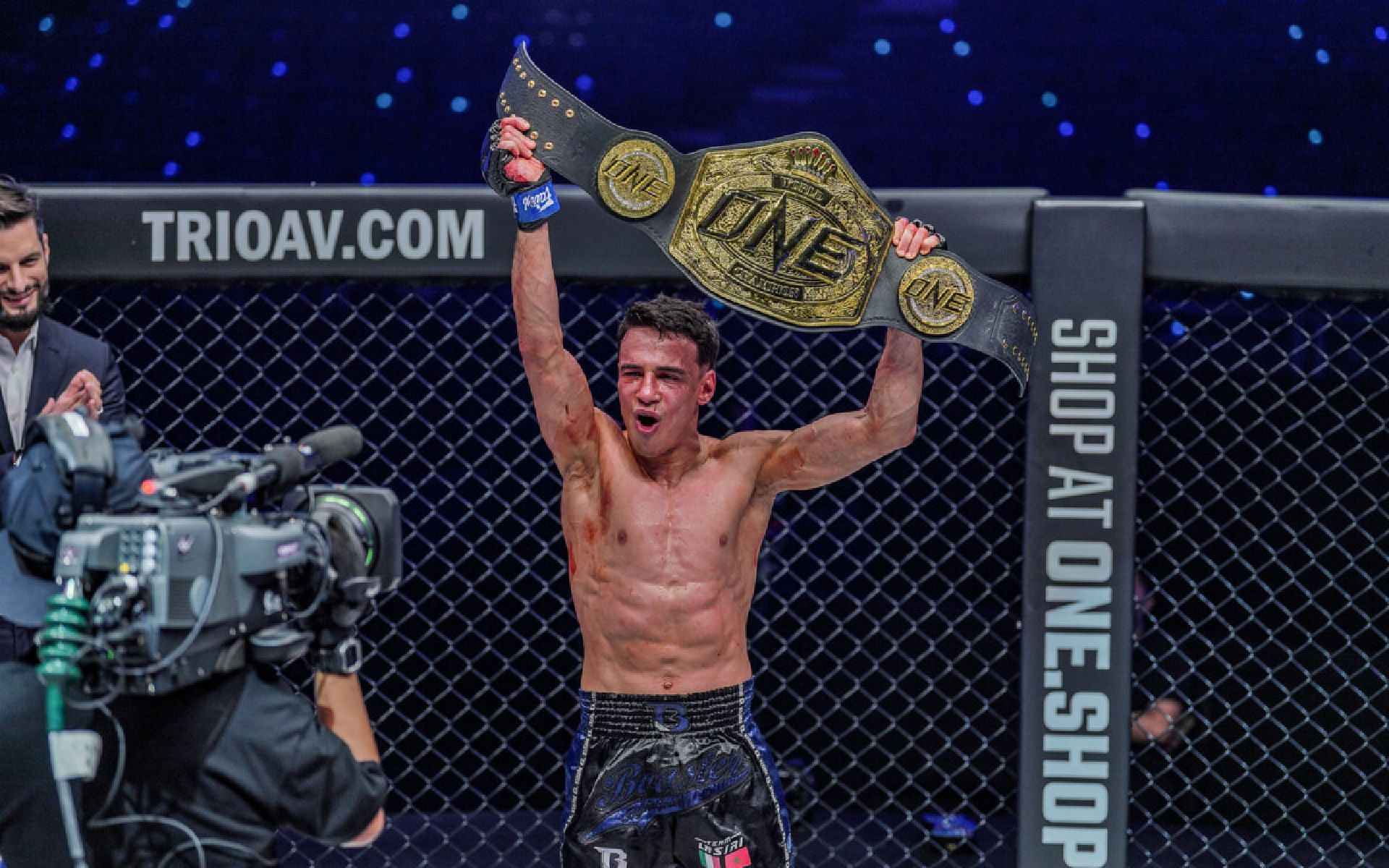 Joseph Lasiri hoists his ONE strawweight Muay Thai world title up after his match at ONE 157. [Photo ONE Championship]