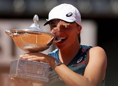 Iga Swiatek bites her second consecutive Italian Open trophy, mirroring idol Rafael Nadal's trademark pose