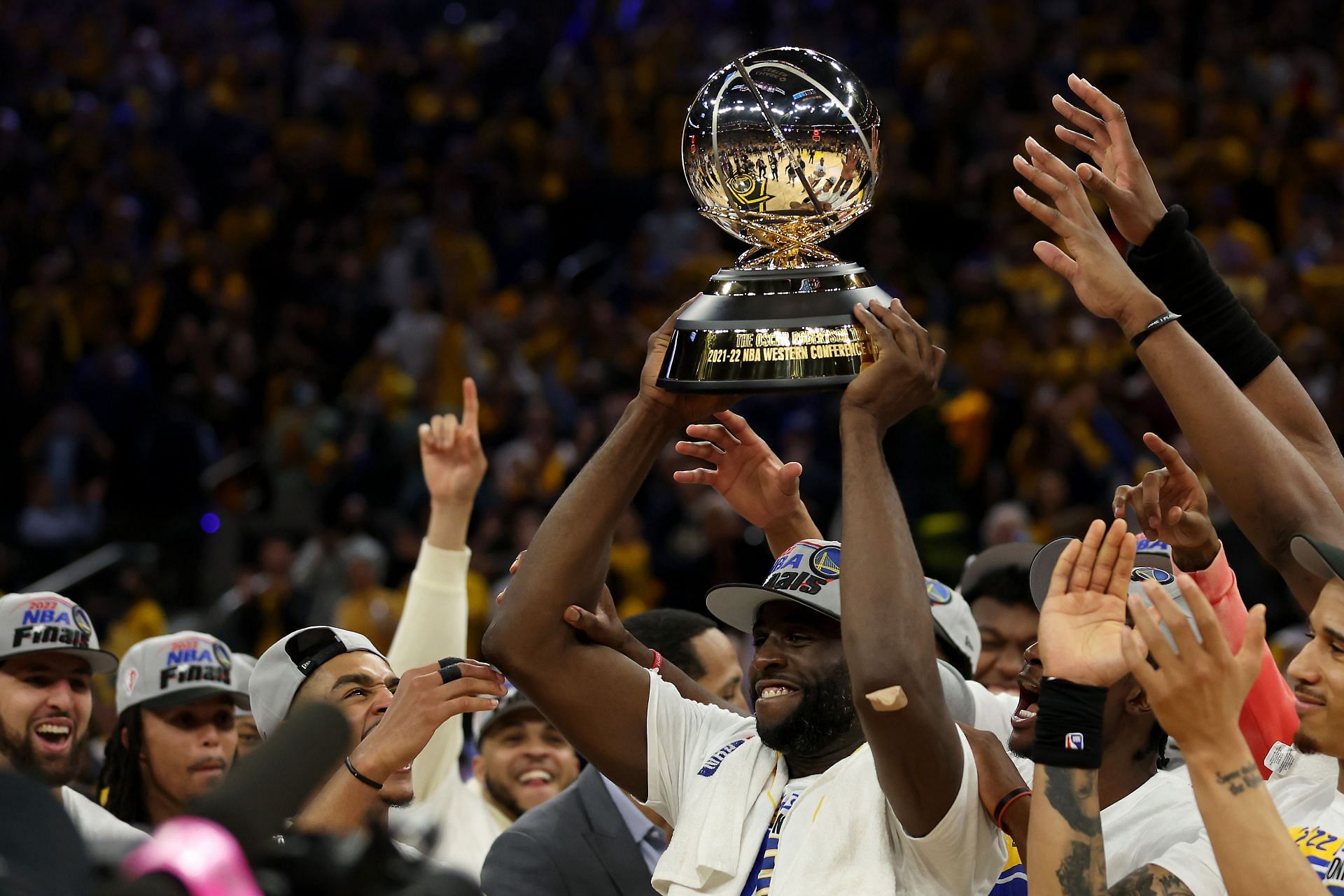 Draymond Green of the Golden State Warriors holds the Western Conference championship trophy.