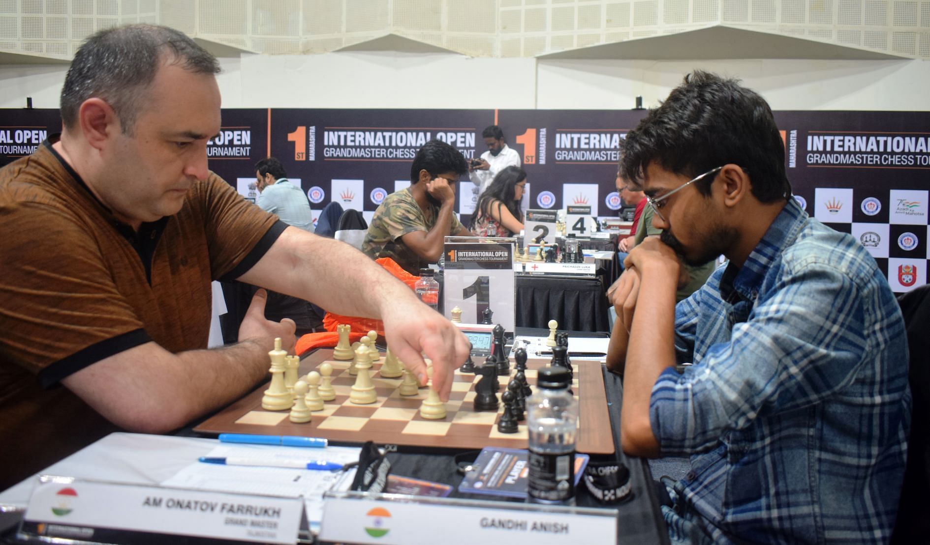 GM Farrukh Amonatov (L) making a move against Anish Gandhi during the opening round of the Maharashtra International Chess tournament in Pune on Tuesday.(Pic credit: AICF)