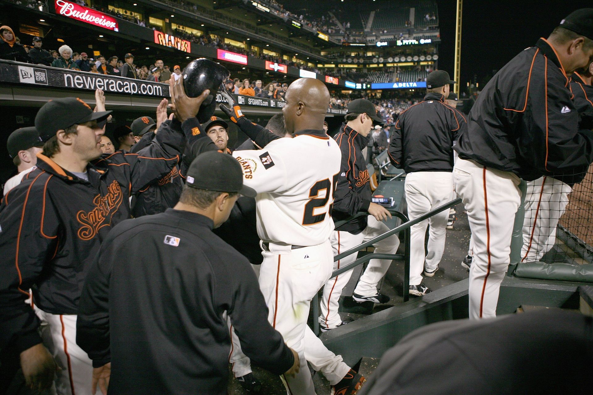 Barry Bonds of the San Francisco Giants is congratulated by teammates in the dugout.
