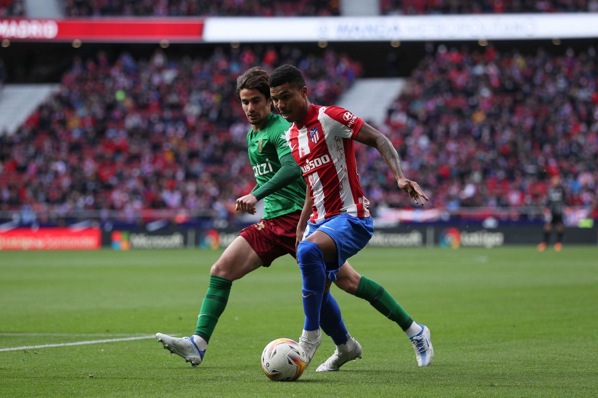 Alex Collado (left) of Granada battles for possession with Atletico Madrid&#039;s Reinildo Mandava (right)