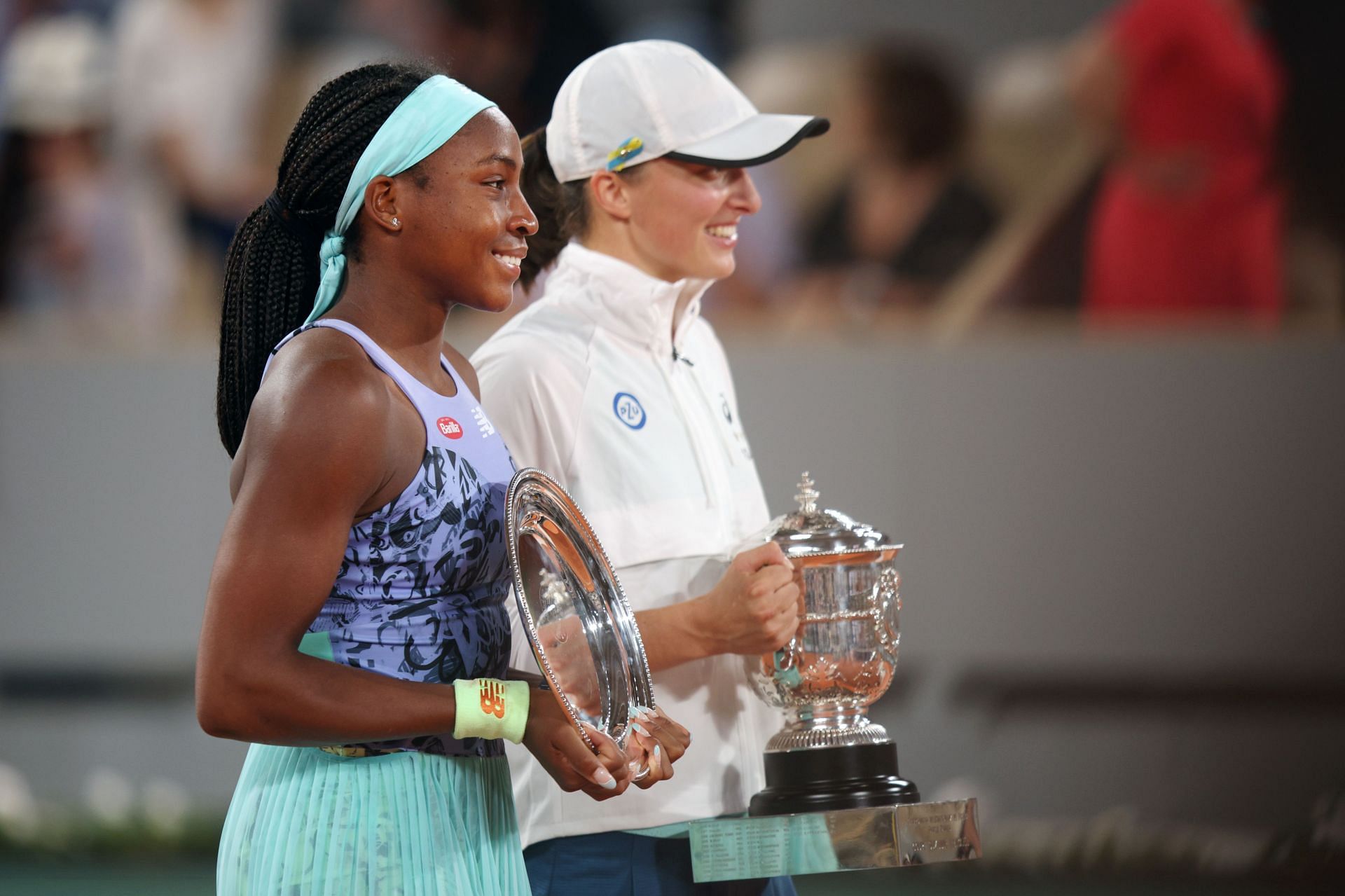 Iga Swiatek and Coco gauff pose with their trophies after the 2022 French Open women's singles final.