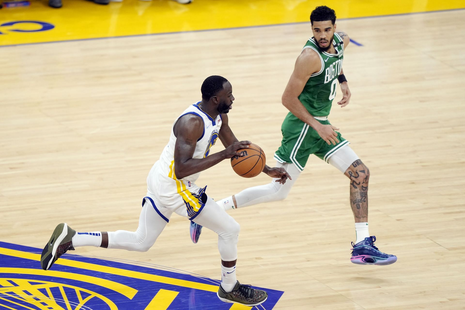 Draymond Green #23 of the Golden State Warriors dribbles against Jayson Tatum #0 of the Boston Celtics