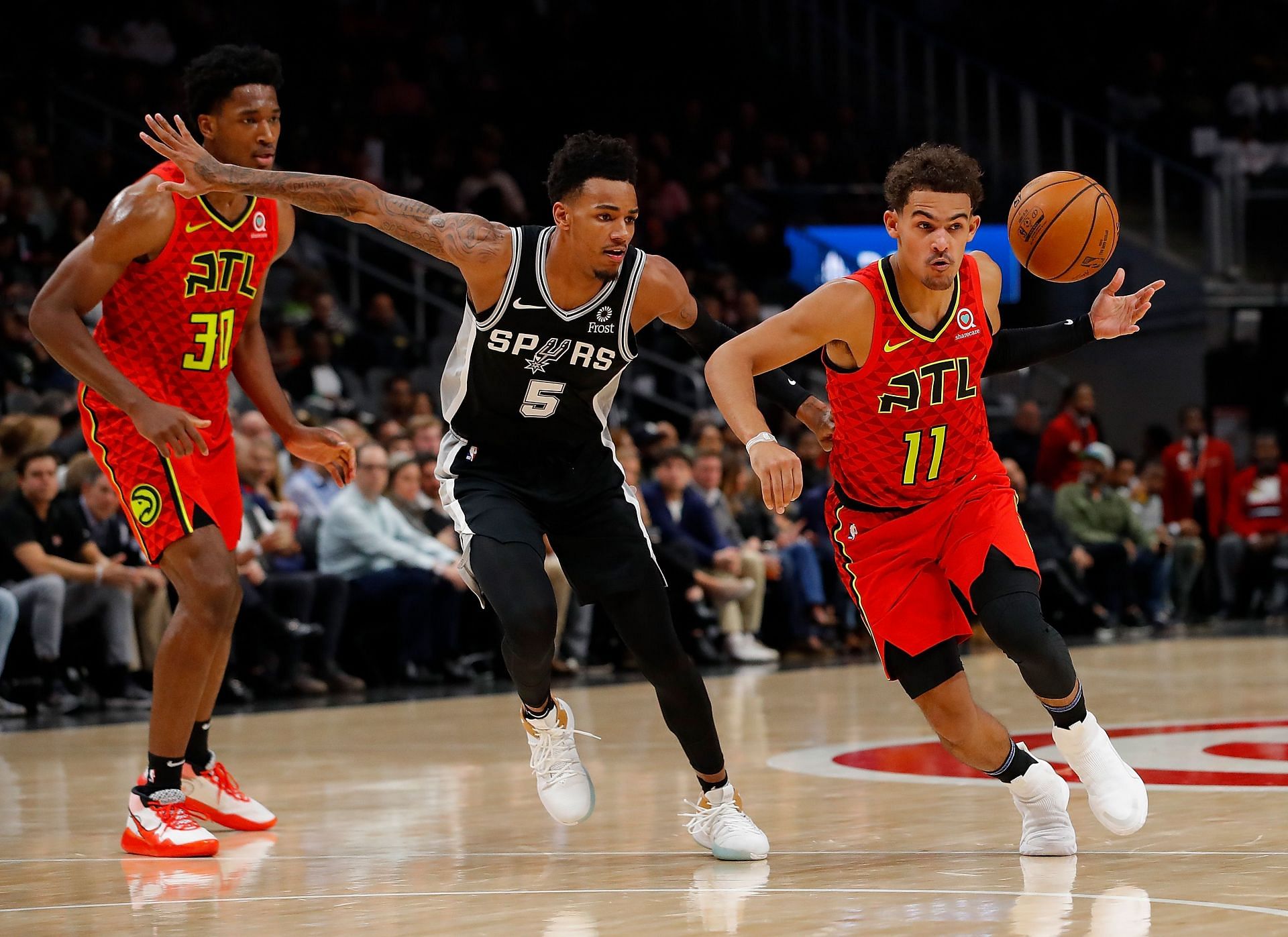 Trae Young of the Atlanta Hawks loses the ball as he drives against Dejounte Murray of the San Antonio Spurs on Nov. 5, 2019, in Atlanta, Georgia.
