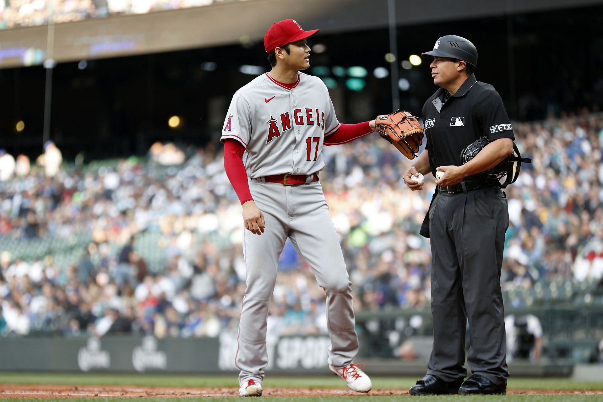 Ohtani chats with the ump during a Los Angeles Angels v Seattle Mariners game.