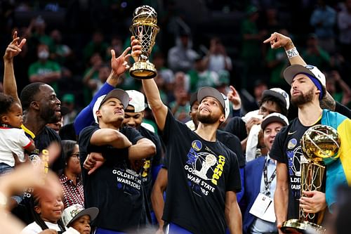 Stephen Curry of the Golden State Warriors raises the Bill Russell NBA Finals Most Valuable Player Award.