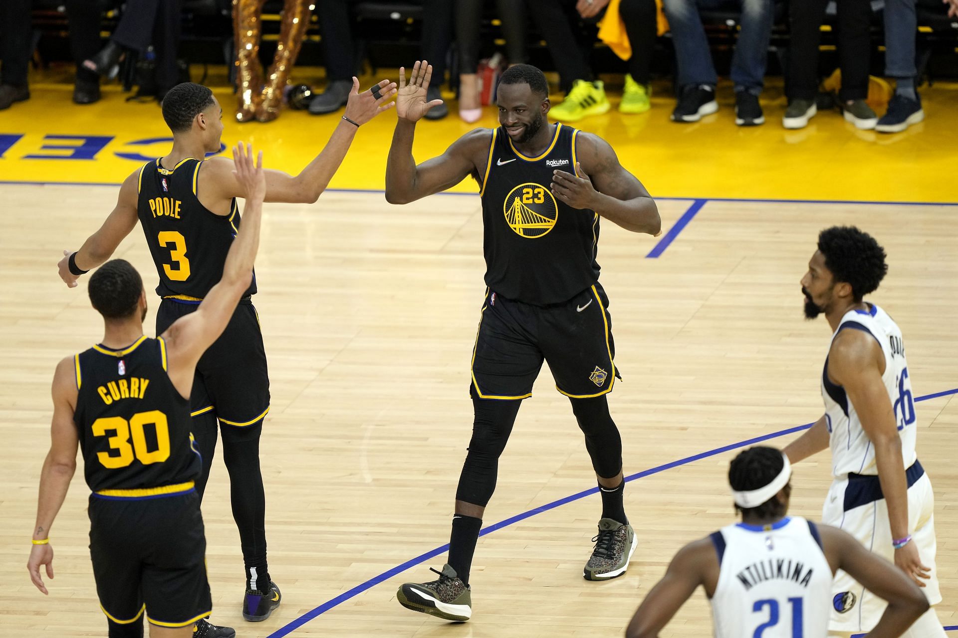 Draymond Green of the Golden State Warriors celebrates with teammates Jordan Poole and Steph Curry.