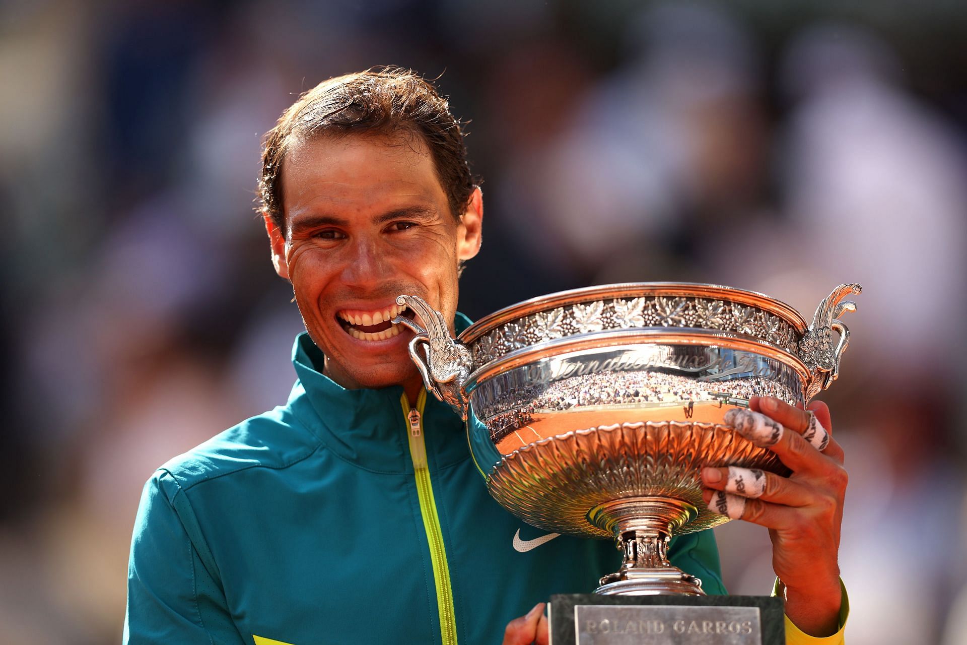 Rafael Nadal with the 2022 French Open, posing in hs trademark style.