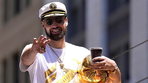 Klay Thompson with the Larry O' Brien trophy